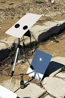 Prints of Viewing a solar eclipse. Pair of binoculars on a telescope projecting an image of a solar eclipse onto a sheet of white card Images Dated 2010 March: Solar Eclipse Projection Print