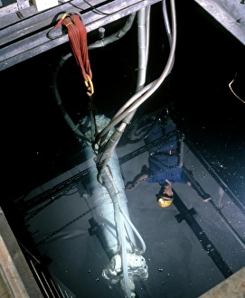 Worker looks at a WIMP detector in a pool of water Worker looks at a WIMP detector in a pool of water