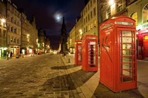 Scotland, Edinburgh, The Royal Mile. Cobbled stone road and traditional red telephone boxes in the High Street Scotland, Edinburgh, The Royal Mile. Cobbled stone road and traditional red telephone boxes in the High Street