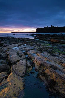 Sunrise over King Edwards Bay viewed from near Sharpness Point. The remains of Tynemouth Priory can be seen to Sunrise over King Edwards Bay viewed from near Sharpness Point. The remains of Tynemouth Priory can be seen to