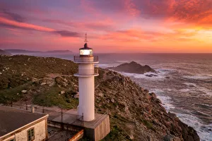Aerial sea landscape view of Cape Tourinan Lighthouse at sunset with pink clouds, Galicia Aerial sea landscape view of Cape Tourinan Lighthouse at sunset with pink clouds, Galicia