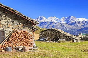 Alpine huts framed by snowy peaks of Bernina Group, Arcoglio Alp, Val Torreggio, Malenco Valley Alpine huts framed by snowy peaks of Bernina Group, Arcoglio Alp, Val Torreggio, Malenco Valley