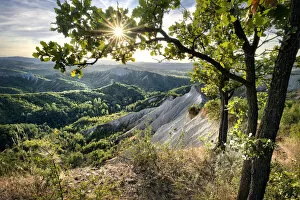 Images Dated 10th February 2021: Badlands and green hills framed by trees and a sunburst, Emilia Romagna, Italy, Europe