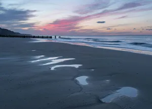 Beautiful sunset colours over the beach at low tide at Mundesley, Norfolk, England Beautiful sunset colours over the beach at low tide at Mundesley, Norfolk, England