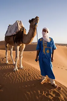 African Landscape Photography Prints: Berber man standing with his camel