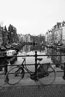 Netherlands Collection: Black and white image of an old bicycle by the Singel canal, Amsterdam