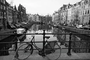 Netherlands Collection: Black and white imge of an old bicycle by the Singel canal, Amsterdam, Netherlands