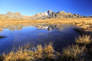 Blue lake frames the peaks of Mount Disgrazia and Cornibruciati, Val Torreggio, Malenco Valley Blue lake frames the peaks of Mount Disgrazia and Cornibruciati, Val Torreggio, Malenco Valley