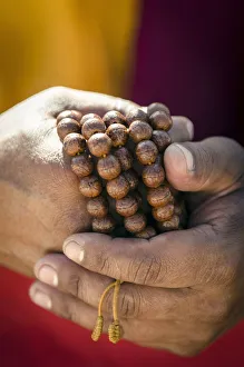 Religion spirituality/buddhist monk holds prayer beads japa mala Religion spirituality/buddhist monk holds prayer beads japa mala