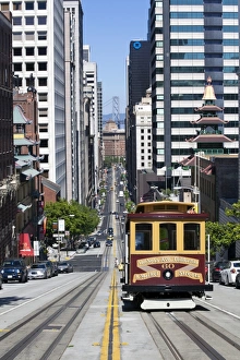 Cable car crossing California Street with Bay Bridge backdrop in San Francisco, California, United States of America Cable car crossing California Street with Bay Bridge backdrop in San Francisco, California, United States of America