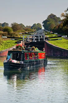 A canal boat leaving the famous series of locks at Caen Hill on the Kennet and Avon Canal, Wiltshire, England A canal boat leaving the famous series of locks at Caen Hill on the Kennet and Avon Canal, Wiltshire, England