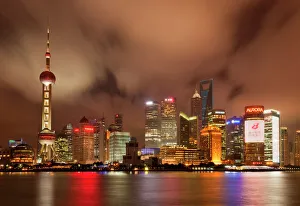 City skyline at night with Oriental Pearl Tower and Pudong skyscrapers across the Huangpu River City skyline at night with Oriental Pearl Tower and Pudong skyscrapers across the Huangpu River