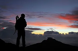 A climber looks towards Mawenzi from near the summit of Mount Kilimanjaro at dawn A climber looks towards Mawenzi from near the summit of Mount Kilimanjaro at dawn