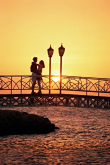 Couple on bridge at sunset, Aruba, West Indies, Dutch Caribbean, Central America Couple on bridge at sunset, Aruba, West Indies, Dutch Caribbean, Central America