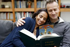 Couple reading the Bible at home, Paris, France, Europe Couple reading the Bible at home, Paris, France, Europe