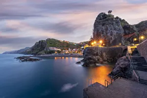 Dusk lights over the seaside town resort of Ponta do Sol washed by the ocean Dusk lights over the seaside town resort of Ponta do Sol washed by the ocean