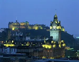 Edinburgh Castle and the Waverley Hotel clock tower illuminated at dusk Edinburgh Castle and the Waverley Hotel clock tower illuminated at dusk