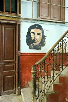 Faded mural of Che Guevara on the staircase of a dilapidated apartment building Faded mural of Che Guevara on the staircase of a dilapidated apartment building