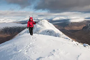 A female walker approaching the summit of Stob Dubh on Buchaille Etive Beag on a A female walker approaching the summit of Stob Dubh on Buchaille Etive Beag on a