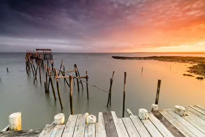 Fiery sky at dawn on the Palafito Pier in the Carrasqueira Natural Reserve of Sado River Fiery sky at dawn on the Palafito Pier in the Carrasqueira Natural Reserve of Sado River