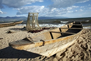 A fisherman tends his nets on Plage des Cocotiers (Coconut Beach) also known as Saga Beach