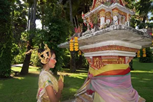 Girl in traditional Thai clothes praying at a spirit house Girl in traditional Thai clothes praying at a spirit house