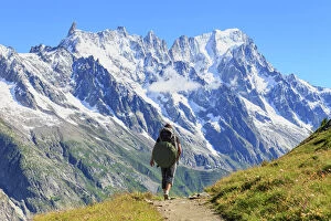 Images Dated 15th July 2016: Hiker runs along trail with views on Grandes Jorasses and the Giant Tooth, Veny Valley