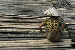 Iban tribeswoman mending bamboo longhouse verandah floor, Lemanak River Iban tribeswoman mending bamboo longhouse verandah floor, Lemanak River