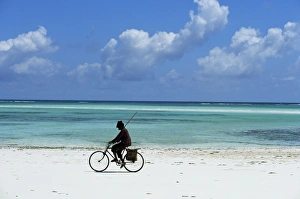 A man riding his bicycle of Kiwengwa beach, island of Zanzibar, Tanzania A man riding his bicycle of Kiwengwa beach, island of Zanzibar, Tanzania