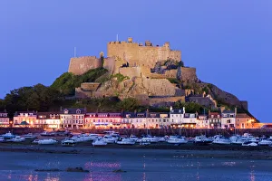 Mount Orgueil Castle, illuminated at dusk, overlooking Grouville Bay in Gorey Mount Orgueil Castle, illuminated at dusk, overlooking Grouville Bay in Gorey