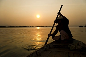 Old lady rowing in Hoi An harbour silhouetted at sunset, Vietnam, Indochina, Southeast Asia, Asia Old lady rowing in Hoi An harbour silhouetted at sunset, Vietnam, Indochina, Southeast Asia, Asia