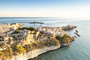 Old town of Vieste perched on cliffs at sunrise, aerial view, Foggia province Old town of Vieste perched on cliffs at sunrise, aerial view, Foggia province