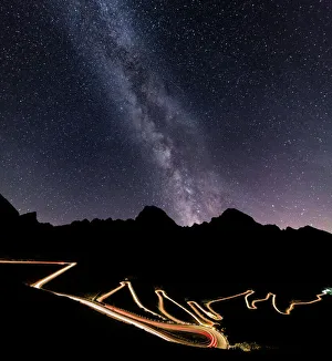 Panorama of the Milky Way and lights of car trace at Stelvio Pass, Valtellina, Lombardy Panorama of the Milky Way and lights of car trace at Stelvio Pass, Valtellina, Lombardy