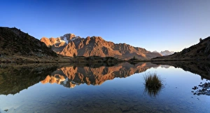 Panorama of the rocky peaks of Mount Disgrazia reflected in Lake Zana at dawn, Malenco Valley Panorama of the rocky peaks of Mount Disgrazia reflected in Lake Zana at dawn, Malenco Valley