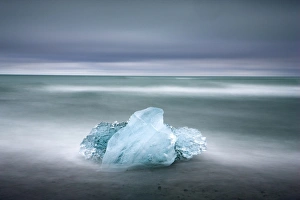 Piece of glacial ice washed ashore by the incoming tide near glacial lagoon at Jokulsarlon Piece of glacial ice washed ashore by the incoming tide near glacial lagoon at Jokulsarlon
