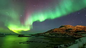 Pink and green aurora borealis (Northern Lights) photographed reflected in the sea near Tromso, Norway, Scandinavia Pink and green aurora borealis (Northern Lights) photographed reflected in the sea near Tromso, Norway, Scandinavia