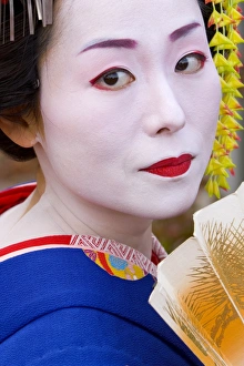 Portrait of a geisha holding a traditional paper fan Portrait of a geisha holding a traditional paper fan