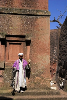 Priest holding cross swings an incense burner at the rock-hewn monolithic church of Bet Priest holding cross swings an incense burner at the rock-hewn monolithic church of Bet