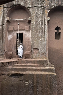 A priest stands at the entrance to the rock-hewn church of Bet Gabriel-Rufael A priest stands at the entrance to the rock-hewn church of Bet Gabriel-Rufael