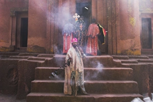 Priest swings an incense burner at the rock-hewn monolithic church of Bet Giyorgis (St Priest swings an incense burner at the rock-hewn monolithic church of Bet Giyorgis (St