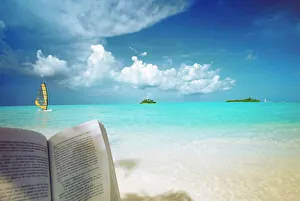 Reading book on the beach, windsurfing and islands in the distance, the Maldives Reading book on the beach, windsurfing and islands in the distance, the Maldives