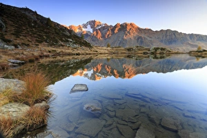 Rocky peaks of Mount Disgrazia reflected in Lake Zana at sunrise, Malenco Valley Rocky peaks of Mount Disgrazia reflected in Lake Zana at sunrise, Malenco Valley