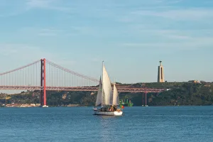 Sailboat navigating on the Tagus River near the Ponte 25 de Abril, Belem, Lisbon Sailboat navigating on the Tagus River near the Ponte 25 de Abril, Belem, Lisbon