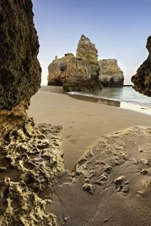 Images Dated 3rd July 2015: A sea cave frames the ocean and the imposing cliffs at dawn, Praia da Rocha, Portimao