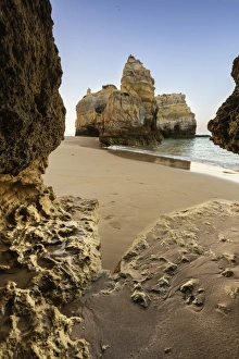 Portugal Coastal Scenery Prints: A sea cave frames the ocean and the imposing cliffs at dawn, Praia da Rocha, Portimao