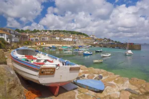 Small boat on the quay and small boats in the enclosed harbour at Mousehole Small boat on the quay and small boats in the enclosed harbour at Mousehole