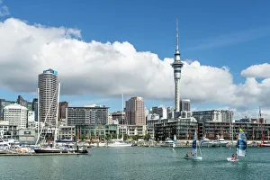 Small sailboats cruise in Auckland harbour in front of the city skyline, Auckland Small sailboats cruise in Auckland harbour in front of the city skyline, Auckland