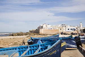 Small wooden fishing boats on seafront with white buildings of the Medina beyond Small wooden fishing boats on seafront with white buildings of the Medina beyond