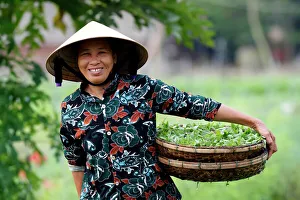 Smiling Vietnamese woman wearing the traditional palm leaf conical hat, Hoi An, Vietnam Smiling Vietnamese woman wearing the traditional palm leaf conical hat, Hoi An, Vietnam