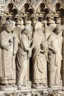Detail of St. Denis holding his head flanked by two angels, Virgin portal, Western facade Detail of St. Denis holding his head flanked by two angels, Virgin portal, Western facade